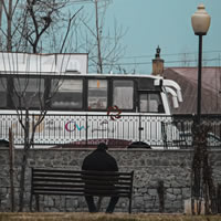 unemployed man sitting on bench in park